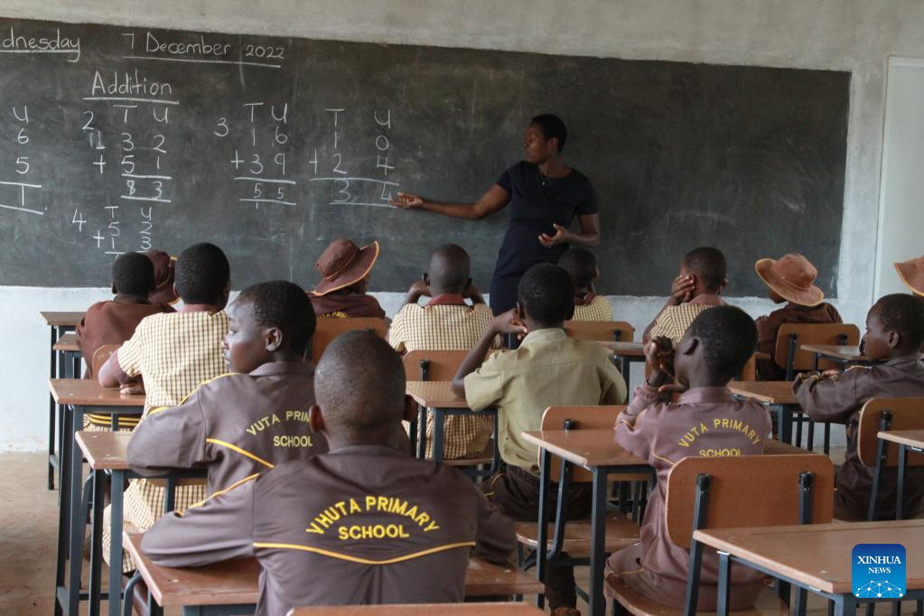 jovem professora ensinando aula de matemática para alunos na sala