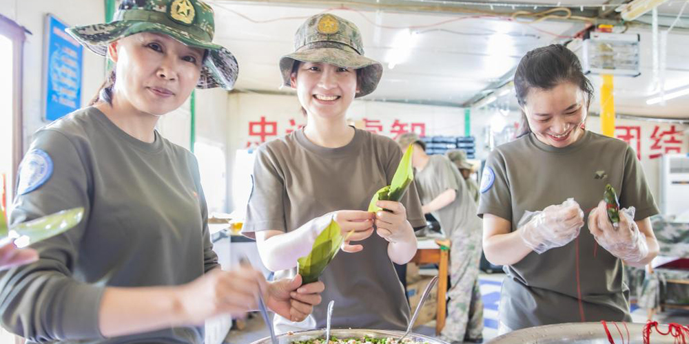 Soldados chineses de manutenção de paz preparam Zongzi para comemorar Festival do Barco-Dragão