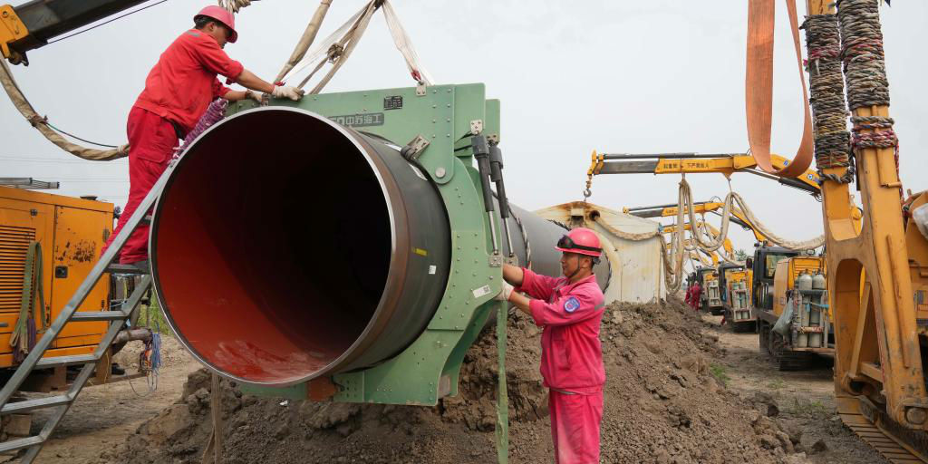 Trabalhadores instalam seção tubular no local de construção do oleoduto de saída da estação de recepção de GNL na cidade de Tangshan