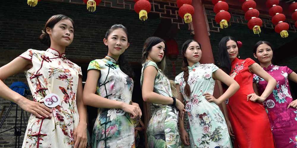Chinesas em vestidos tradicionais durante um desfile para promover o turismo