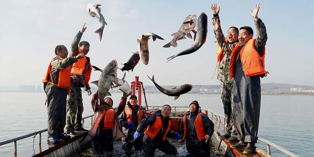 Pescadores pescam peixes no reservatório de Luhun no centro da China