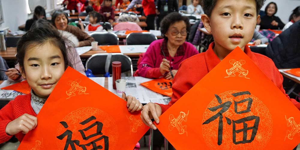 Moradores de Beijing escrevem caractere chinês "Fu" para saudar o próximo Festival da Primavera