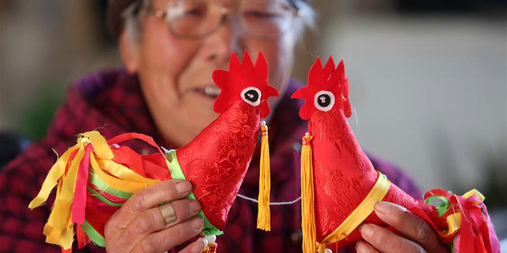 Artista popular Du Yifang faz bonecos de galo para trazer boa sorte no ano novo