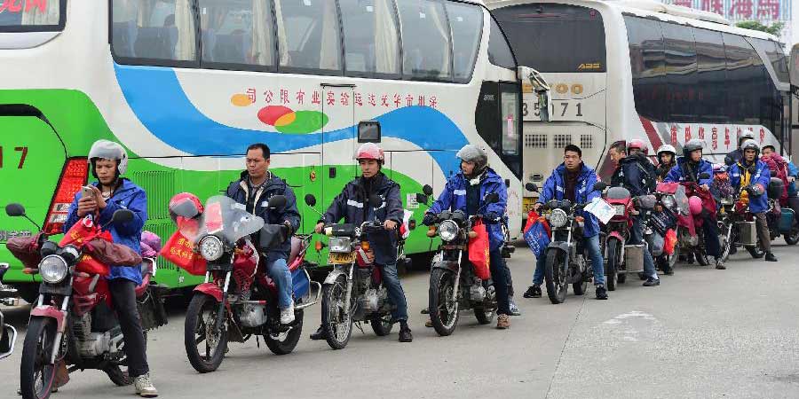Trabalhadores migrantes andam de motocicleta para casa para Festival da Primavera