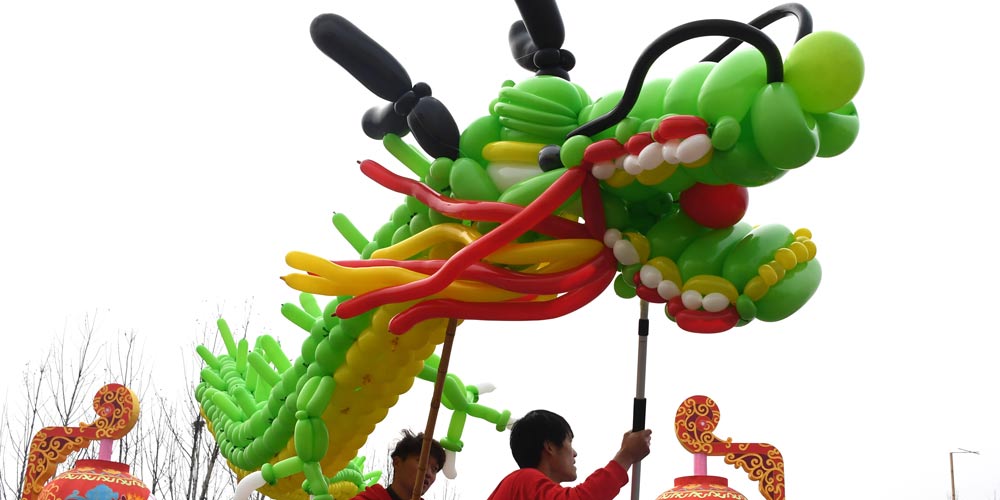 Pessoas apresentam dança do dragão em Wuhan