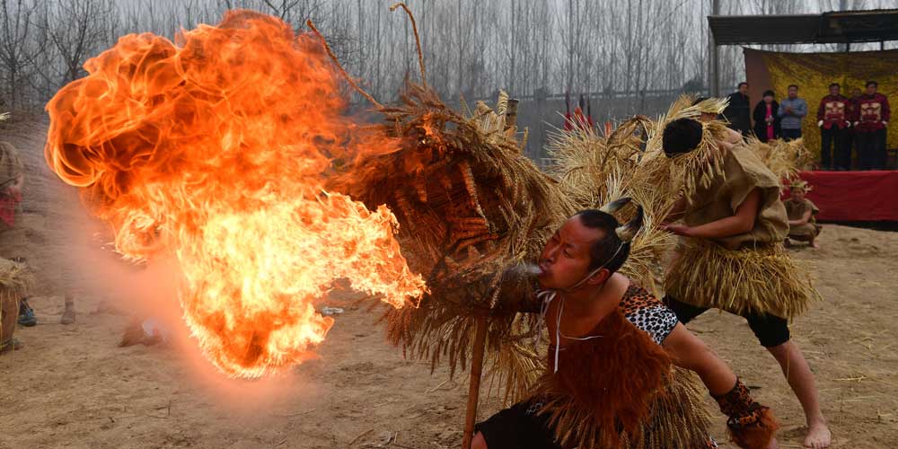Artistas executam dança do dragão de palha em Henan no centro da China