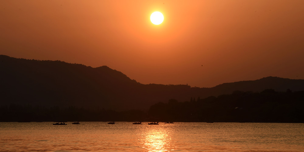 Turistas apreciam o pôr do sol no Lago do Oeste