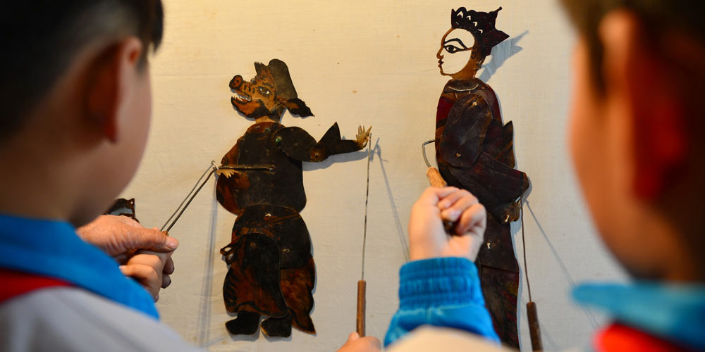 Artistas de bonecos de sombra ensinam cultura tradicional para alunos no norte da China