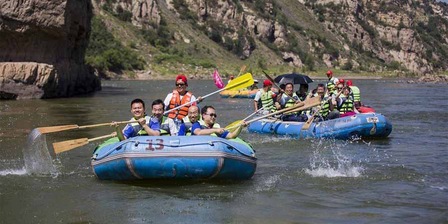 Turistas praticam rafting no rio Amarelo em Shanxi