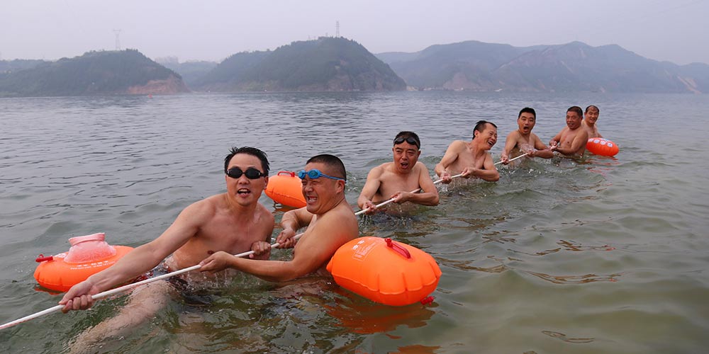 Nadadores se divertem com cabo de guerra na água em Hubei