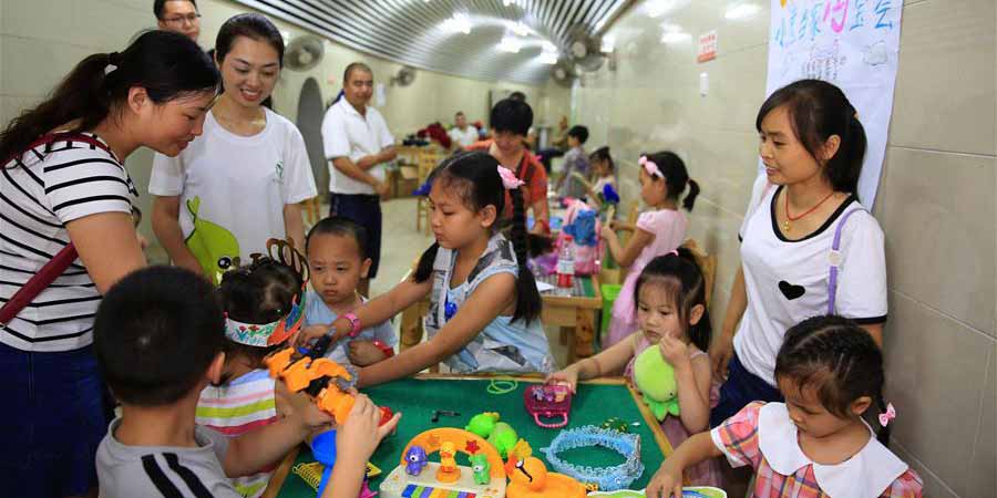Crianças vendem brinquedos usados em mercado de pulgas em Chonqqing