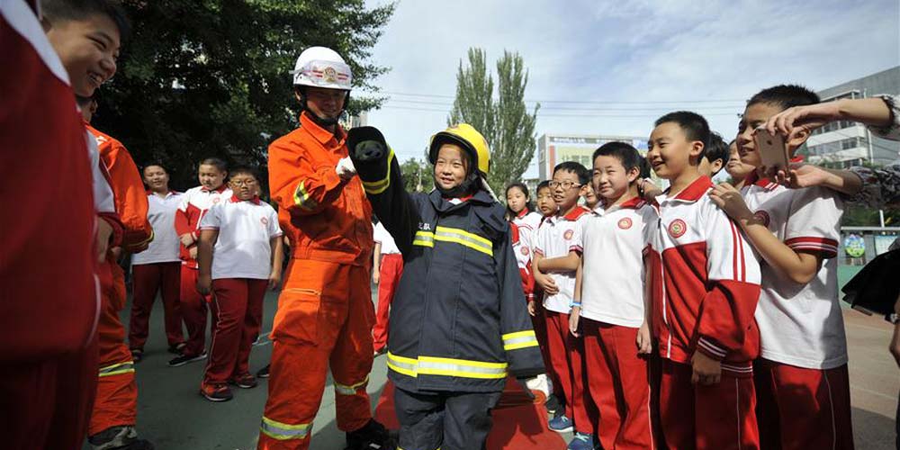 Crianças têm treinamento de combate a incêndio como primeira aula do novo semestre em Hebei