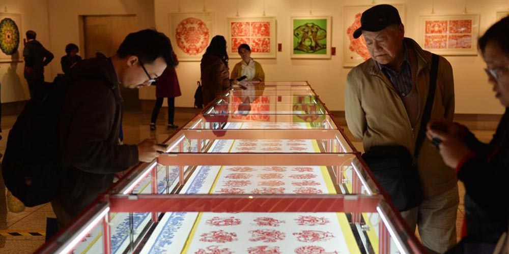 Tradicional arte chinesa de corte de papel em exposição em Beijing