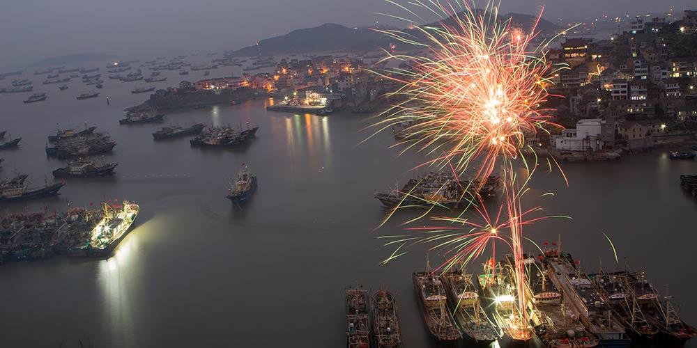 Fogos de artifício iluminam céu em porto pesqueiro em celebração ao Ano Novo Lunar chinês