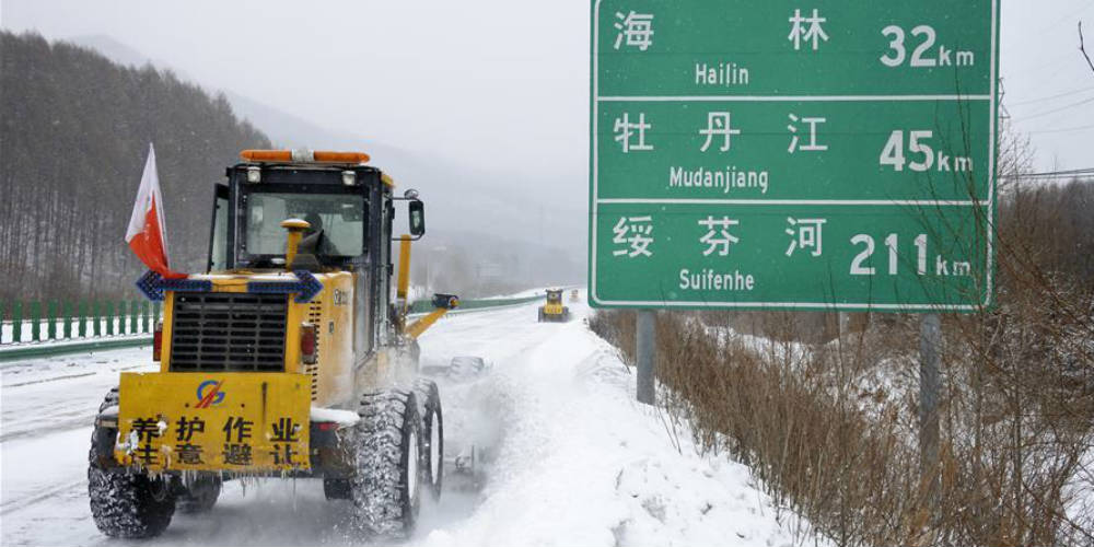 Caminhões removem neve em via expressa no nordeste da China