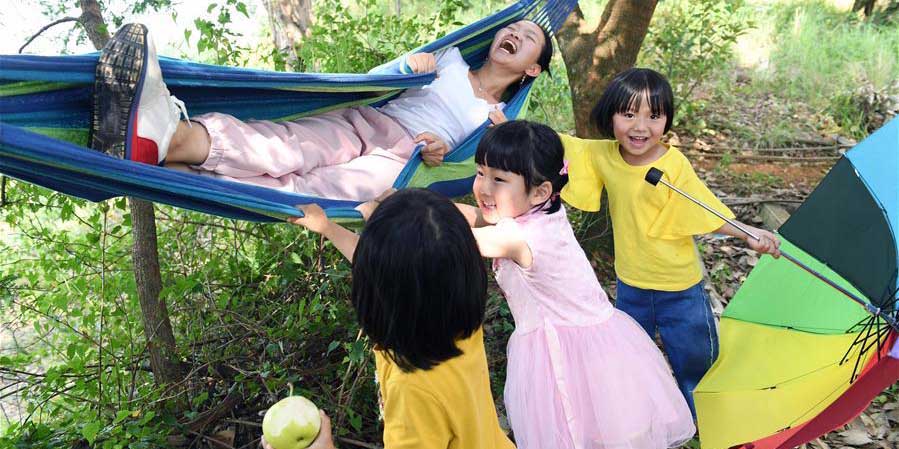 Crianças se divertem no pomar em Kunming, na China Yunnan