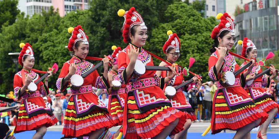 Mulheres do grupo étnico Yi apresentam trajes tradicionais em Yunnan