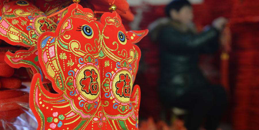 Aldeões fazem nós chineses para o Festival da Primavera em Hebei