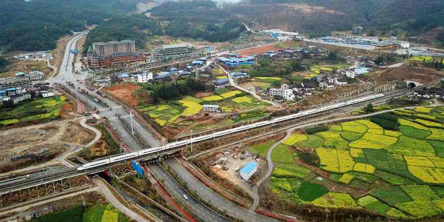 Trem de alta velocidade passa pelos campos de canola em Guizhou