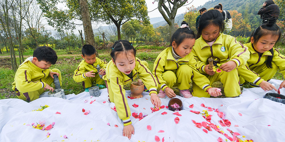 Crianças utilizam folhas e flores em atividade de pintura em Zhejiang