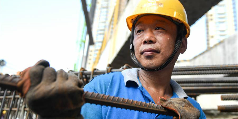Construtores continuam seu trabalho durante dias quentes de verão em Zhejiang, leste da China