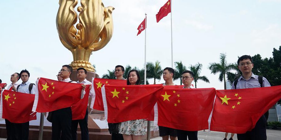 Jovens seguram bandeira nacional da China durante mobilização relâmpago em Hong Kong