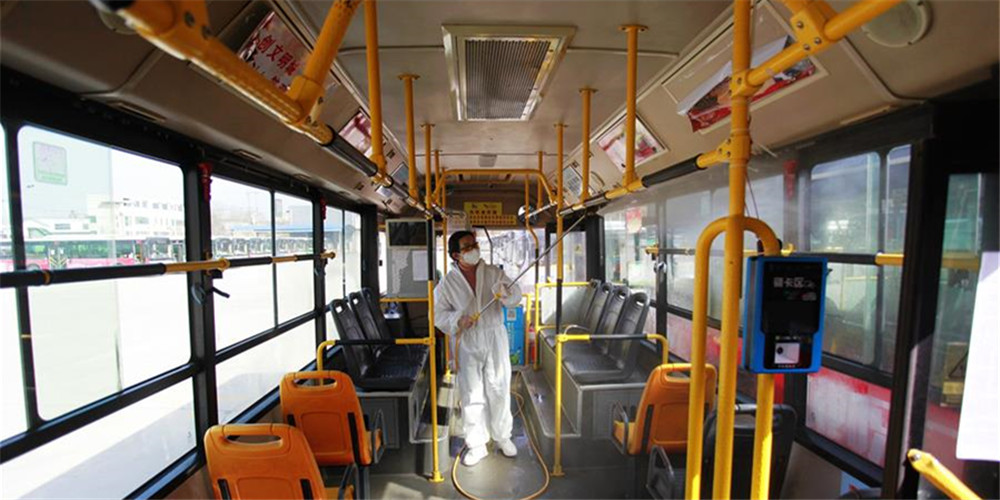 Funcionários desinfectam ônibus em Yichang