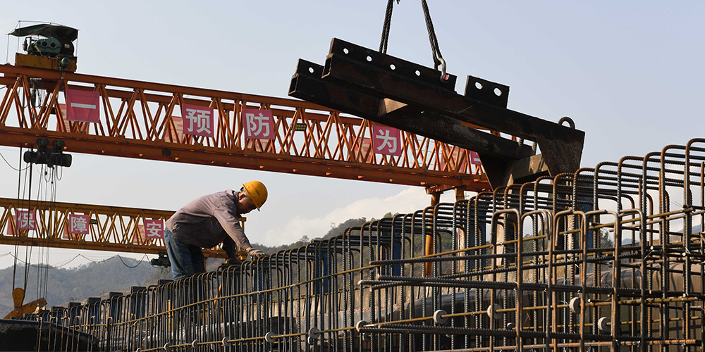 Trabalhadores constroem vigas de ponte para a rodovia Mojiang-Lincang na província de Yunnan