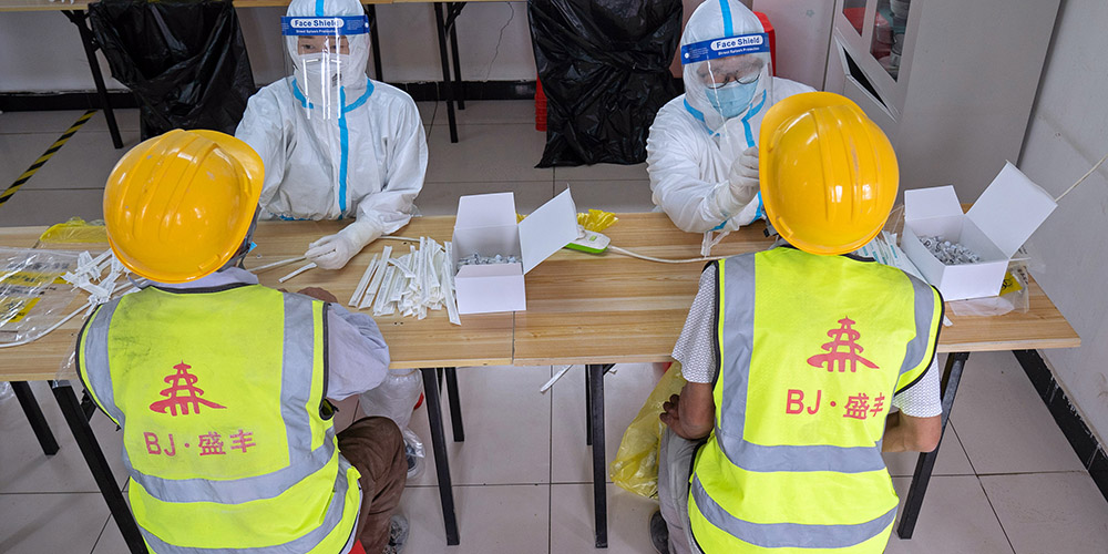 Trabalhadores da construção recebem teste do ácido nucleico no distrito de Daxing em Beijing