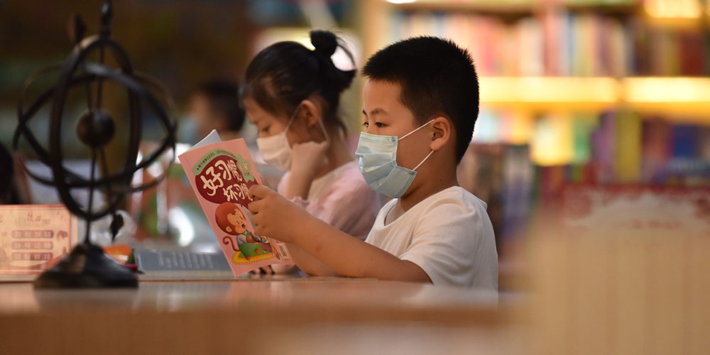 Crianças leem em livraria de Dingzhou, província de Hebei