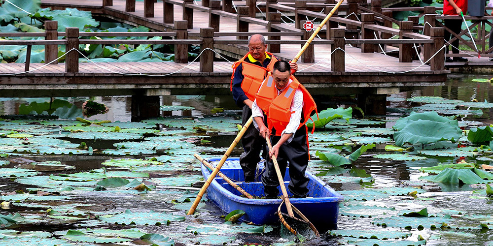 Voluntários retiram lixo de lagoa em Zhejiang