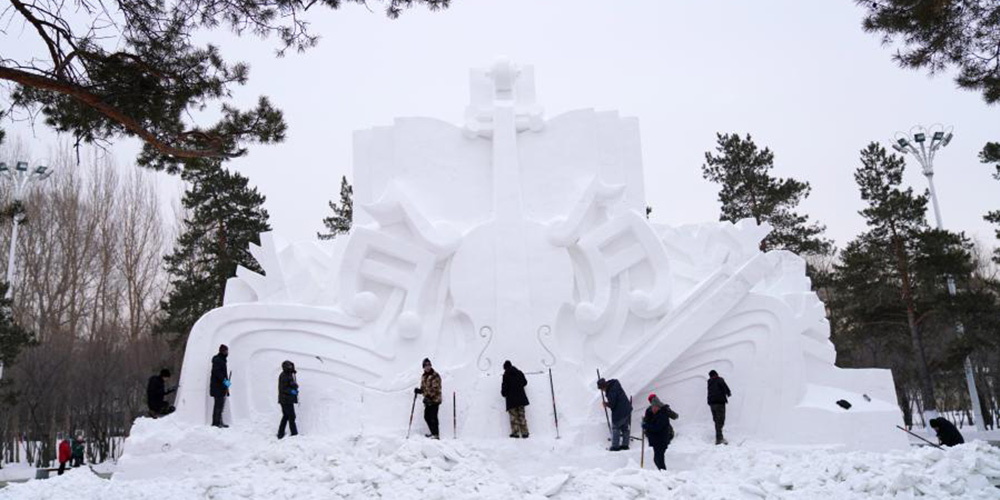 Pessoas trabalham em esculturas de neve gigantes em Harbin