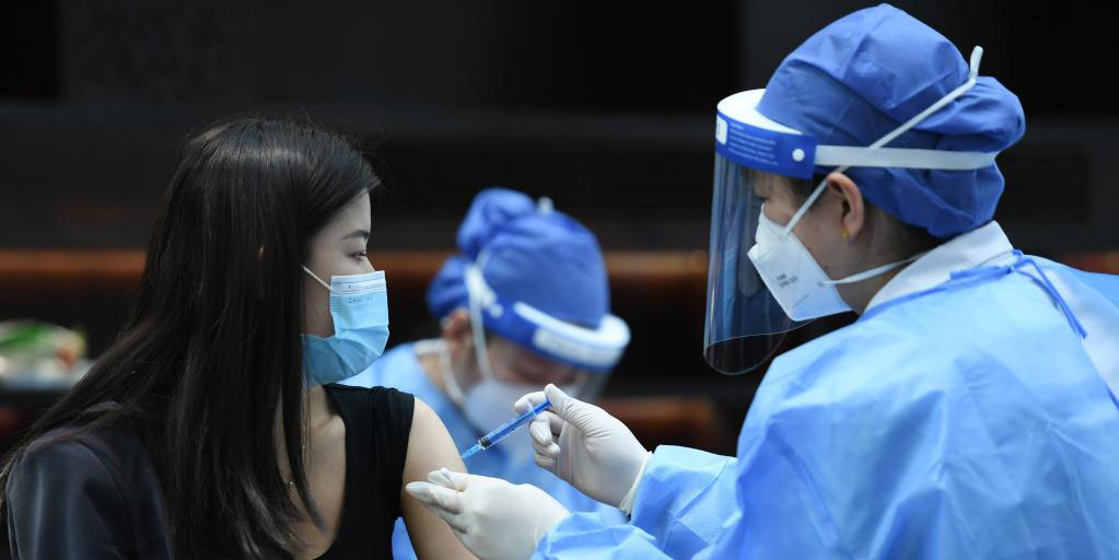 Comerciantes e funcionários de centros comerciais recebem vacinação contra COVID-19 em Beijing